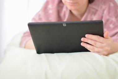 Sabahları evde tablet kullanan rahat bir kadın.