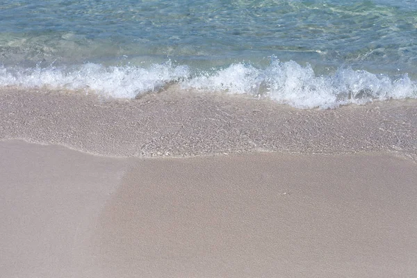 Morbida onda di oceano blu sulla spiaggia di sabbia. Contesto. Focus selettivo. — Foto Stock