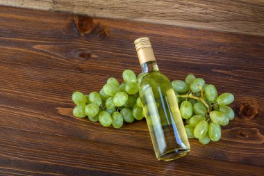 Bir şişe beyaz şarap üzüm ahşap zemin ile