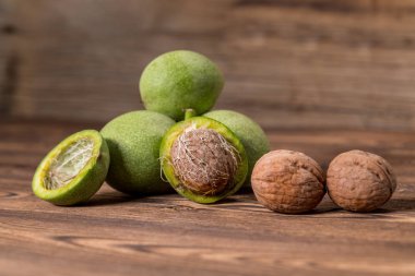 Ceviz ahşap arka plan üzerinde taze hasat. Yeşil ve kahverengi fındık. Kabuk ve ceviz kabuğu. Ceviz ahşap yüzeye