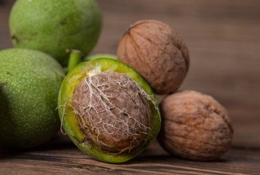 Ceviz ahşap arka plan üzerinde taze hasat. Yeşil ve kahverengi fındık. Kabuk ve ceviz kabuğu. Ceviz ahşap yüzeye
