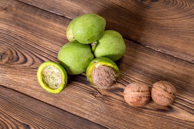 Ceviz ahşap arka plan üzerinde taze hasat. Yeşil ve kahverengi fındık. Kabuk ve ceviz kabuğu. Ceviz ahşap yüzeye