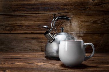 ahşap arka plan üzerinde metalik çaydanlık