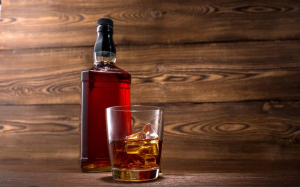 Fles whisky op een houten achtergrond — Stockfoto