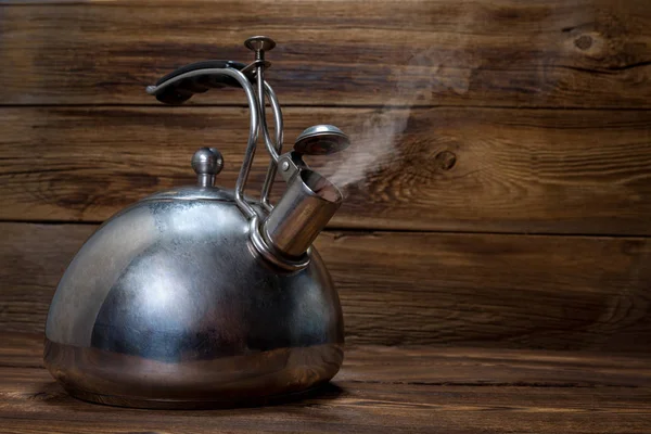 ahşap arka plan üzerinde metalik çaydanlık
