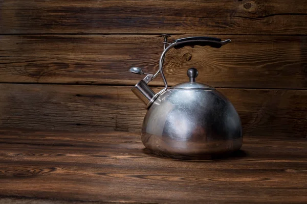 ahşap arka plan üzerinde metalik çaydanlık