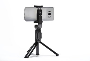 akıllı telefon ve beyaz arka plan üzerinde izole tripod