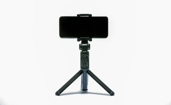 akıllı telefon ve beyaz arka plan üzerinde izole tripod