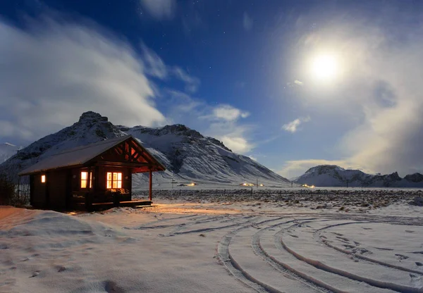 Cottage su uno sfondo di montagne al chiaro di luna. Islanda meridionale . — Foto Stock