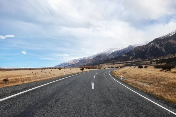 Asphalt road to the National Park Mount Cook in late autumn. — Stock Photo, Image