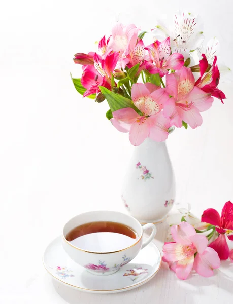 Retro martwa natura z filiżanką herbaty i kwiaty (alstroemeria). — Zdjęcie stockowe