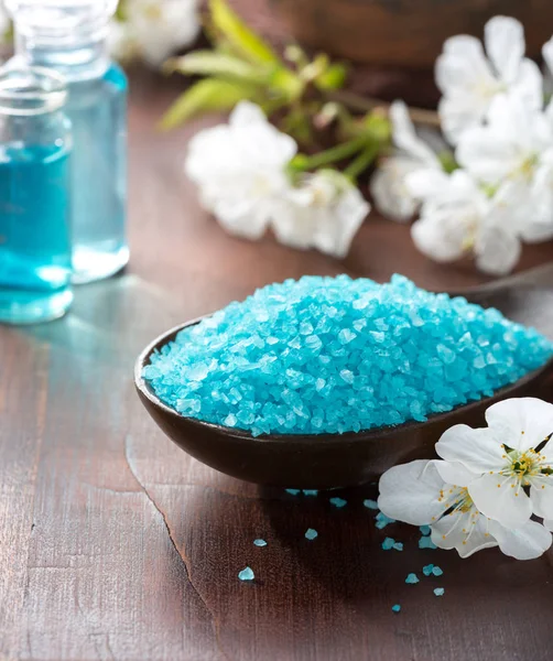 Mineral bath salts, shower gel, towels and spring flowers. — Stock Photo, Image