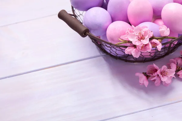 Oeufs de Pâques et branche de pêche en fleurs sur table en bois . — Photo