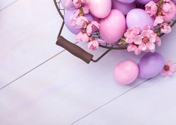 Paskalya yumurtaları ve ahşap masa üzerinde çiçeklenme şeftali şube. — Stok fotoğraf