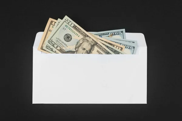 Envelope de papel branco com dinheiro sobre fundo preto — Fotografia de Stock
