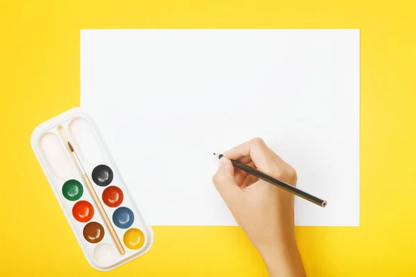 Hand med penna över blankt papper, färger — Stockfoto