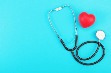 Kırmızı kalp ve mavi bir arka plan üzerinde stetoskop.