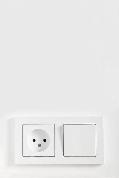 Europeisk elektrisk strömbrytare och uttag på den målade vita väggen — Stockfoto