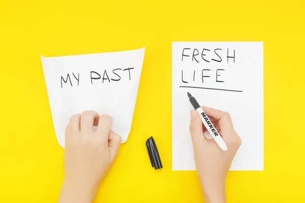 Hand wrinkles a piece of paper with the phrase: My past, and writes on a blank sheet of paper: Fresh life Royalty Free Stock Photos