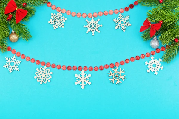 Bordo natalizio con rami di abete rosso, fiocchi di neve, fiocchi di vacanza, giocattoli natalizi su sfondo blu — Foto Stock