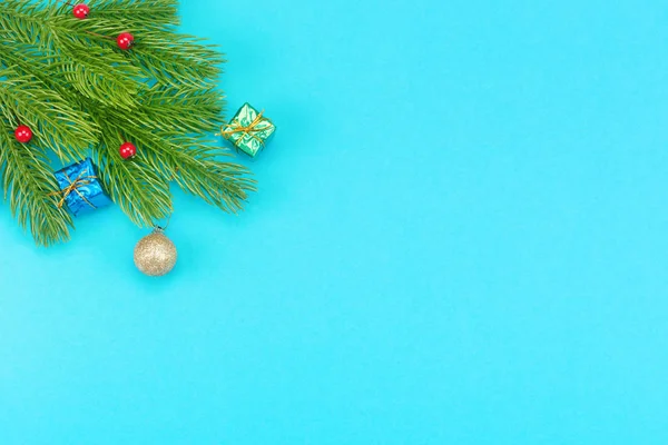 Christmas border with branches of spruce, christmas toys on a blue background — Stock Photo, Image