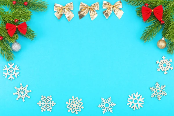 Christmas border with branches of spruce, holidays bows, christmas toys on a blue background — Stock Photo, Image