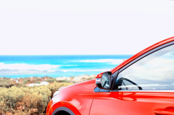 Kumsalda kırmızı bir araba.