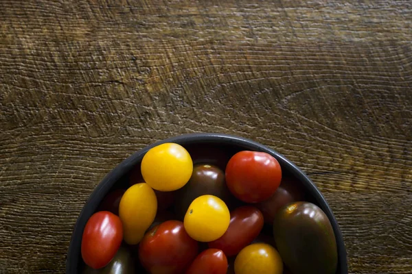 Tomates cherry sobre fondo de madera con copyspace. Vista desde ab —  Fotos de Stock