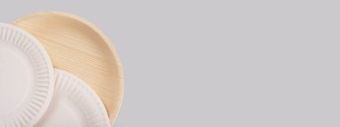 Açık gri arka planda biyolojik olarak bozunabilir yemek tabaklarıyla pankart