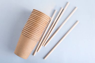 Tek kullanımlık bardaklar ve açık gri arka planda pipetler.