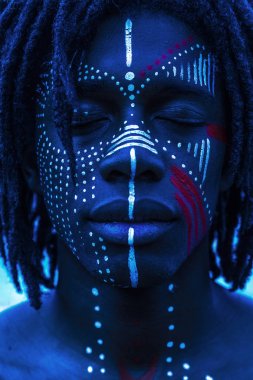 Güçlü özellikleri ve kırmızı ve beyaz yüz boyama ile Afrika kökenli Amerikalı adam portresi