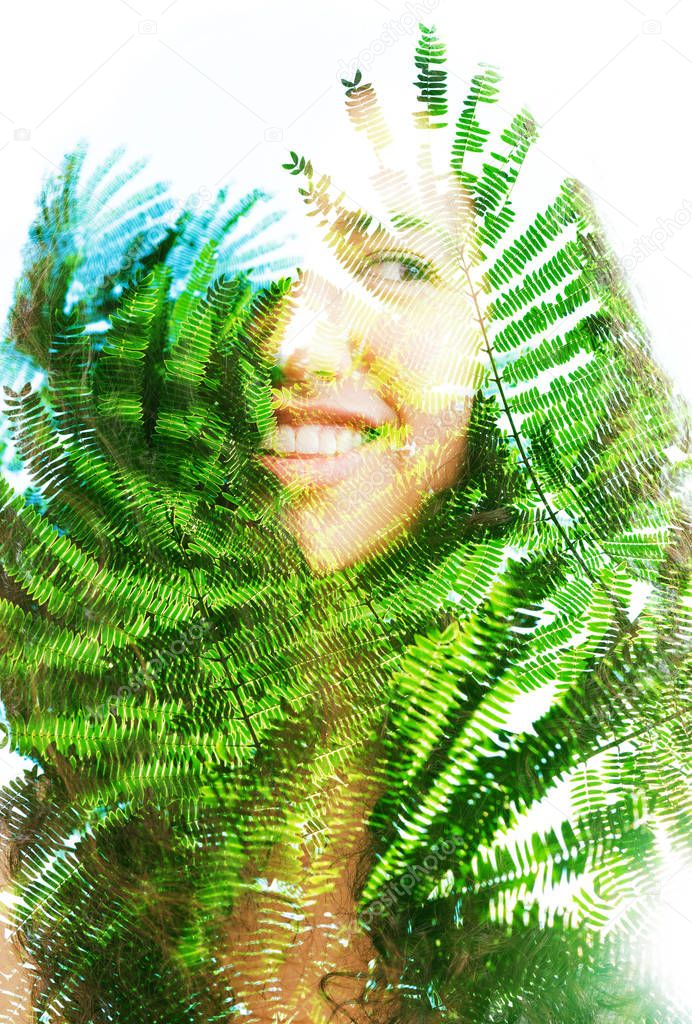Double exposure portrait of beautiful woman with hair blending into texture of branches 