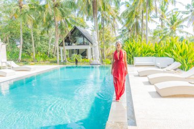 Kırmızı elbiseli genç bayan lüks bir otelde tatilde.