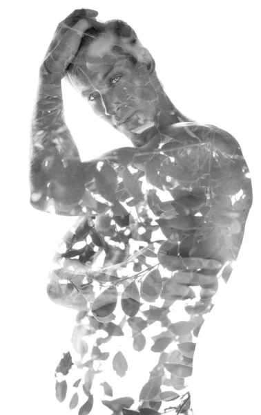 Dubbel exponering av en ung, skjortlös, muskulös man kombinerad med blad av ett träd, svart och vitt — Stockfoto