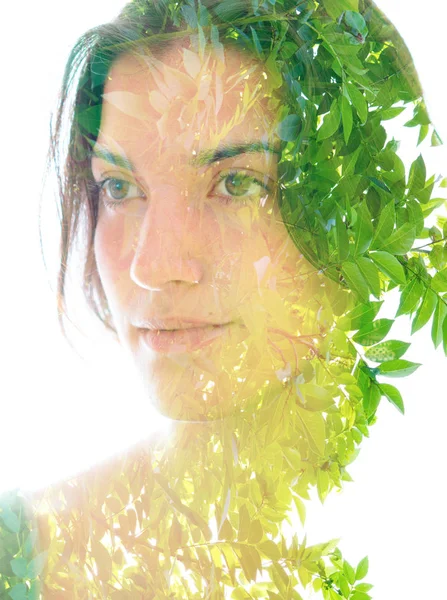 Doble exposición retrato de cerca de una joven mujer bonita entretejida con hojas brillantes de un árbol tropical vibrante —  Fotos de Stock