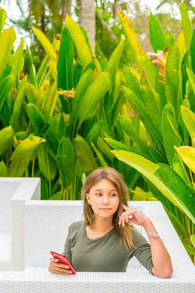 Adolescente usando su teléfono inteligente rojo — Foto de Stock