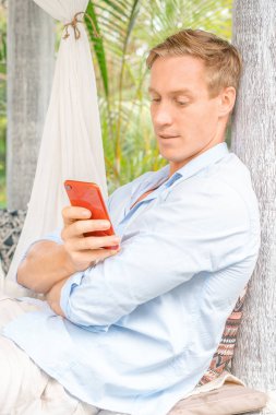 Kırmızı akıllı telefonlu genç adam..