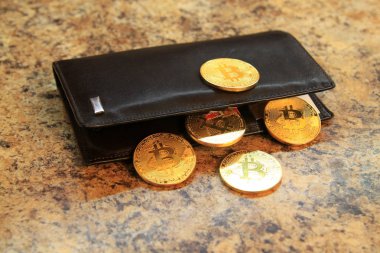 Bitcoin madeni paralarla bir granit zemin üzerine deri cüzdan