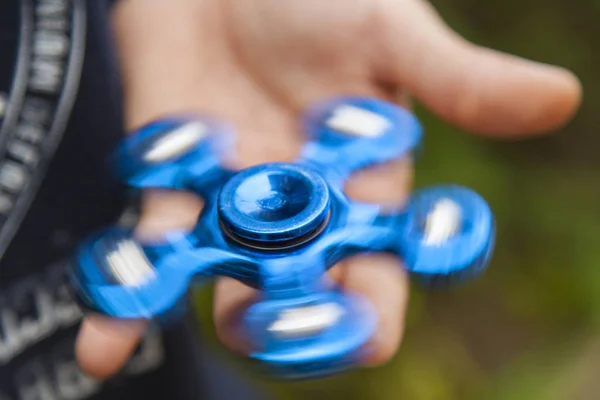 Close up view of hanf of boy on which blue spinner is spinning — Stock Photo, Image