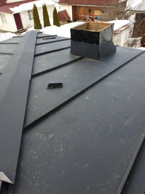 Yeni gri katlanmış metal çatılı modern kulübe yukarıdan görünüyor.