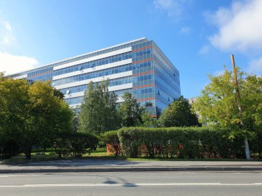 Modern ofis binası yemyeşil ağaçların arasında duruyor.