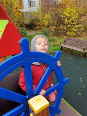 Küçük kız oyun sahasında kaptancılık oynuyor.