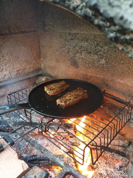 肉のジューシーな切り身は鋳鉄製の鍋で焼かれますバーベキューオーブンで石炭を燃焼 — ストック写真