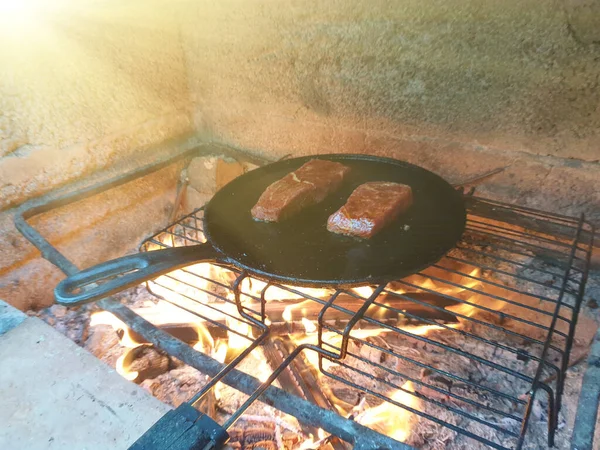 肉のジューシーな切り身は鋳鉄製の鍋で焼かれますバーベキューオーブンで石炭を燃焼 — ストック写真