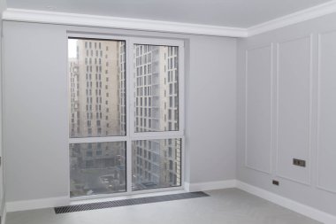Duvarları boiserie ve panoramik pencereli boş gri renkli bir oda.