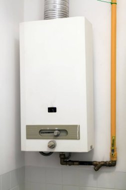 Gaz ısıtıcısı banyodaki duvarda asılı.