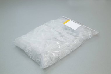 Gri arka planda test tüpleri olan şeffaf çanta.