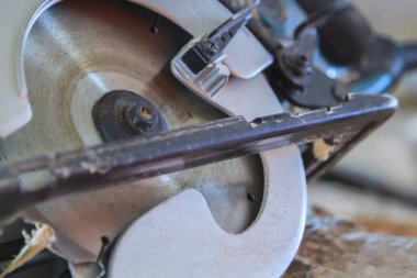 Tahtanın üzerinde el testeresinin yakın görüntüsü var. 