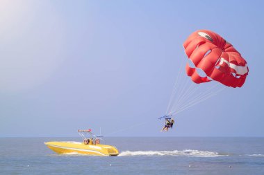 Parasailing - aktif bir eğlence biçimi, hareket halindeki bir tekneye uzun bir iple bağlanmak ve havada süzülen özel paraşüt sayesinde