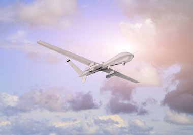 İnsansız hava aracı (UAV) mavi gökyüzünde beyaz bulutların üzerinde uçar. Gün batımında doğal arka plan.
